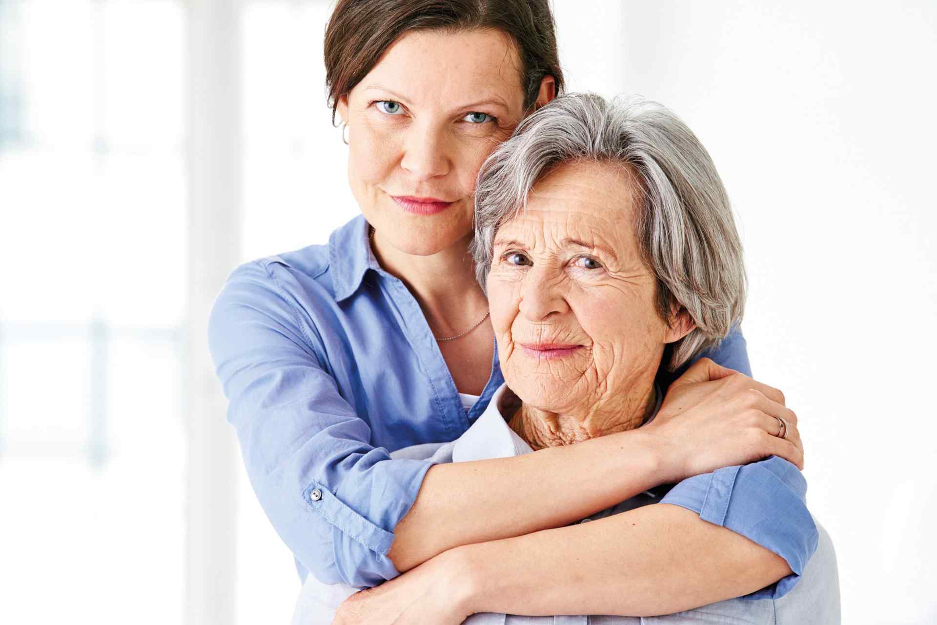 Eine jüngere Frau umarmt eine ältere Frau
